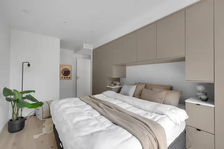 Ved inngangen til rommet er det praktisk skyvedørsgarderobe